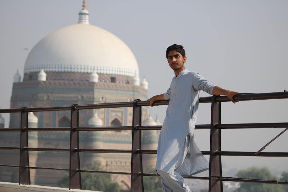 man holding meta tube near Taj mahal