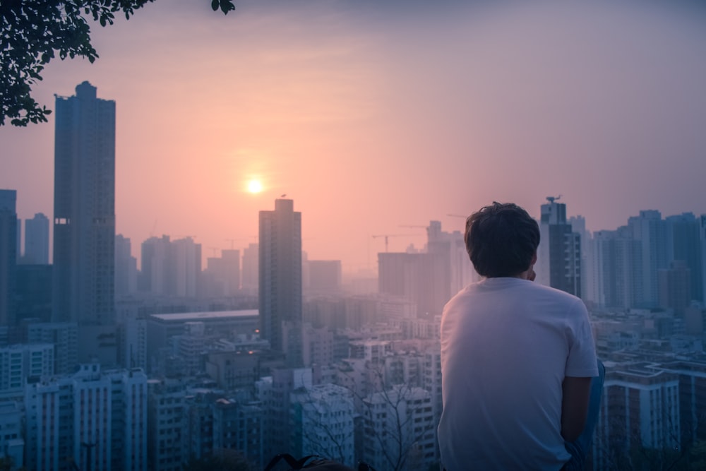 back view of man looks the cityscape at daytime