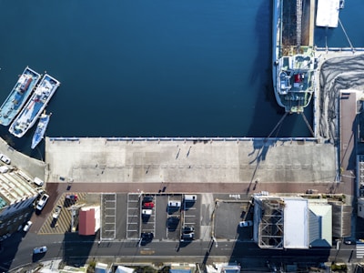 A professional maritime consultant reviewing ship plans on a dockside office overlooking cargo ships.