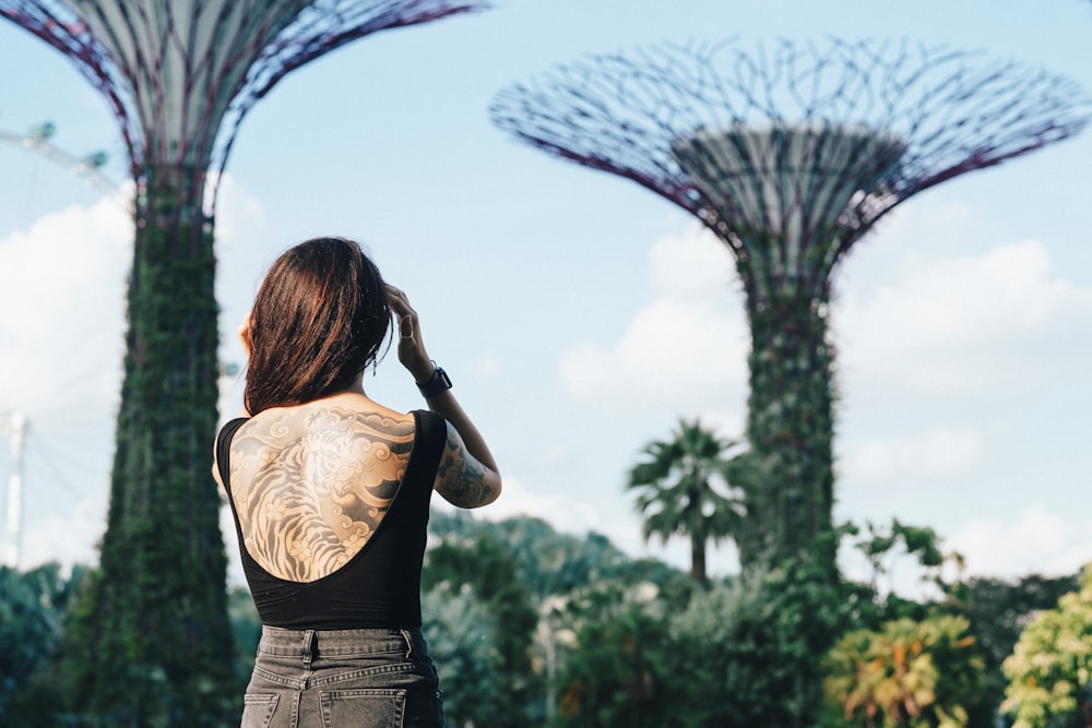 woman in black top standing near garden painting