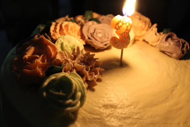 A beautifully decorated birthday cake with fresh flowers and intricate icing details