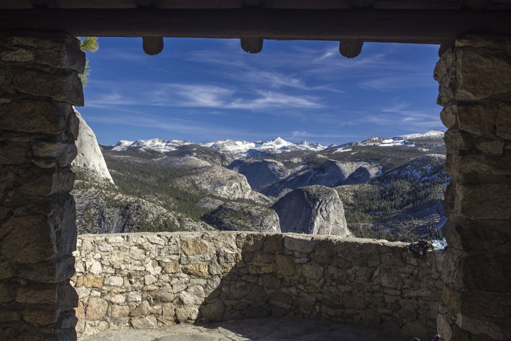 mountains viewed from brown bricked window