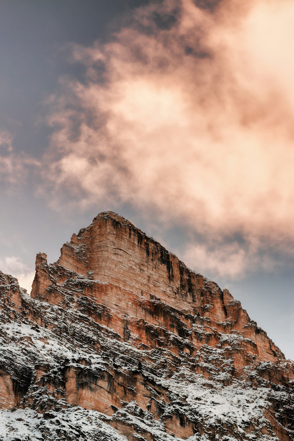 Montanha de rocha marrom sob nuvens brancas durante o dia