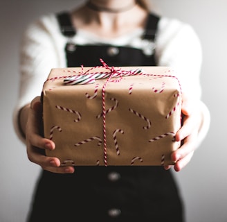 person showing brown gift box