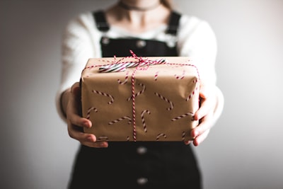 person showing brown gift box give google meet background