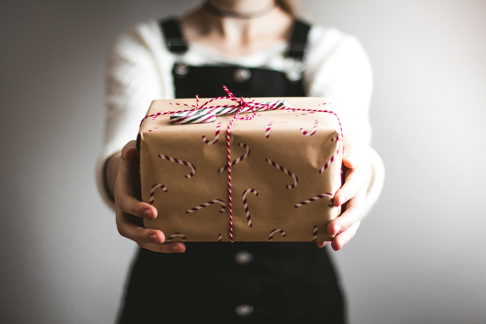 Person holding a brown gift box wrapped with string