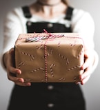 person showing brown gift box