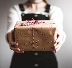 person showing brown gift box