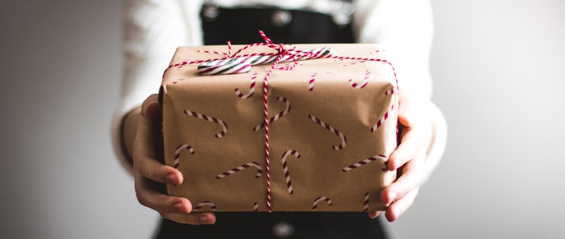 person showing brown gift box