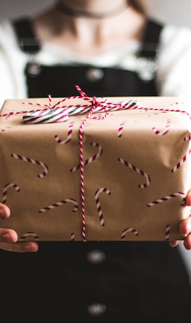 person showing brown gift box