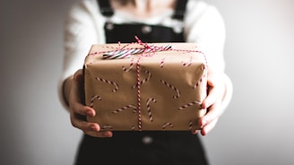 person showing brown gift box