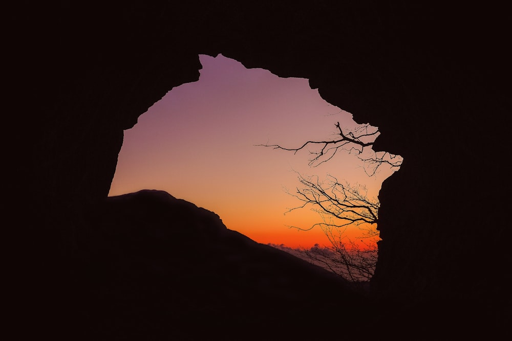 silhouette of cave during sunset