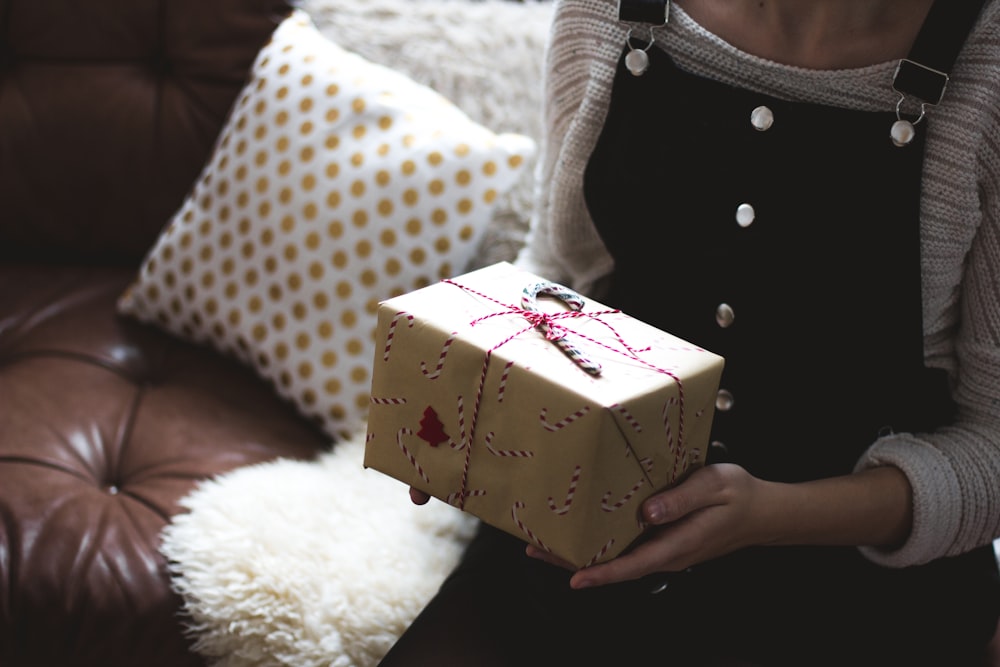 Photographie sélective de mise au point d’une femme tenant une boîte-cadeau