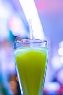 A refreshing homemade drink in a glass with pastel green hues, surrounded by soft cream and blue kitchen decor.