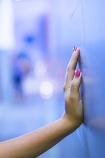 Close-up of hands touching a textured sensory wall with soothing colors.