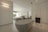 white ceramic bathtub near black textile