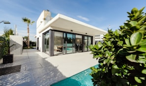 white and grey concrete building near swimming pool under clear sky during daytime