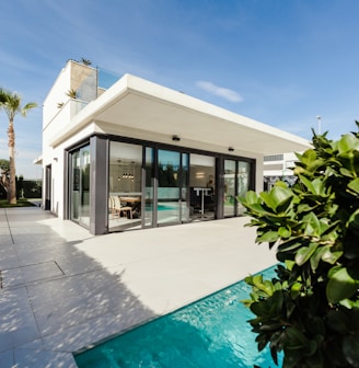 white and grey concrete building near swimming pool under clear sky during daytime