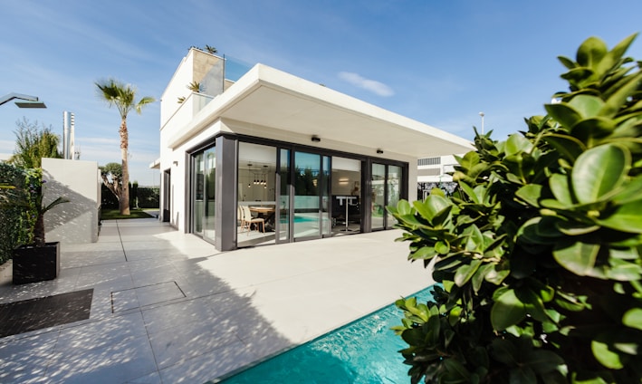 white and grey concrete building near swimming pool under clear sky during daytime