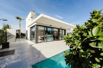 white and grey concrete building near swimming pool under clear sky during daytime