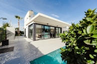 white and grey concrete building near swimming pool under clear sky during daytime