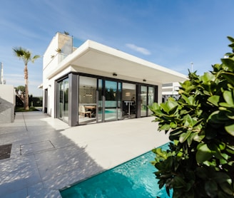 white and grey concrete building near swimming pool under clear sky during daytime