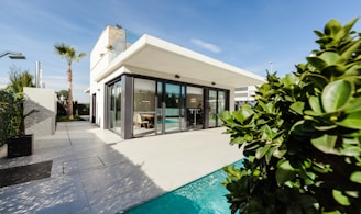 white and grey concrete building near swimming pool under clear sky during daytime