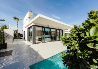 white and grey concrete building near swimming pool under clear sky during daytime