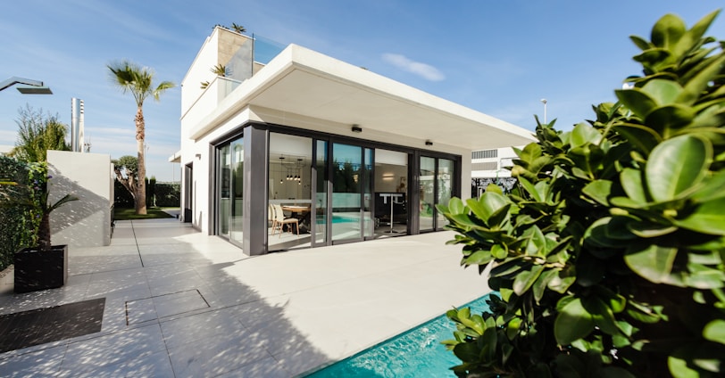 white and grey concrete building near swimming pool under clear sky during daytime