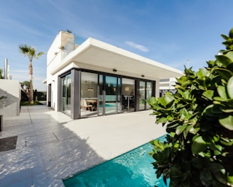 white and grey concrete building near swimming pool under clear sky during daytime