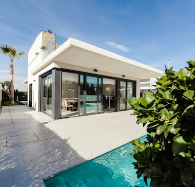 white and grey concrete building near swimming pool under clear sky during daytime