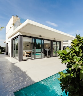 white and grey concrete building near swimming pool under clear sky during daytime