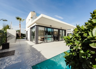 white and grey concrete building near swimming pool under clear sky during daytime