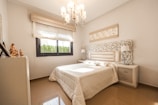 white bed comforter near glass window