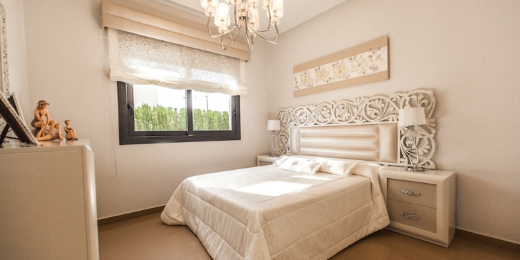 white bed comforter near glass window