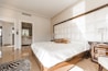 brown wooden bed frame with white cover beside brown wooden nightstand