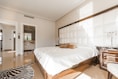 brown wooden bed frame with white cover beside brown wooden nightstand