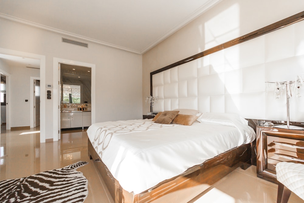 brown wooden bed frame with white cover beside brown wooden nightstand