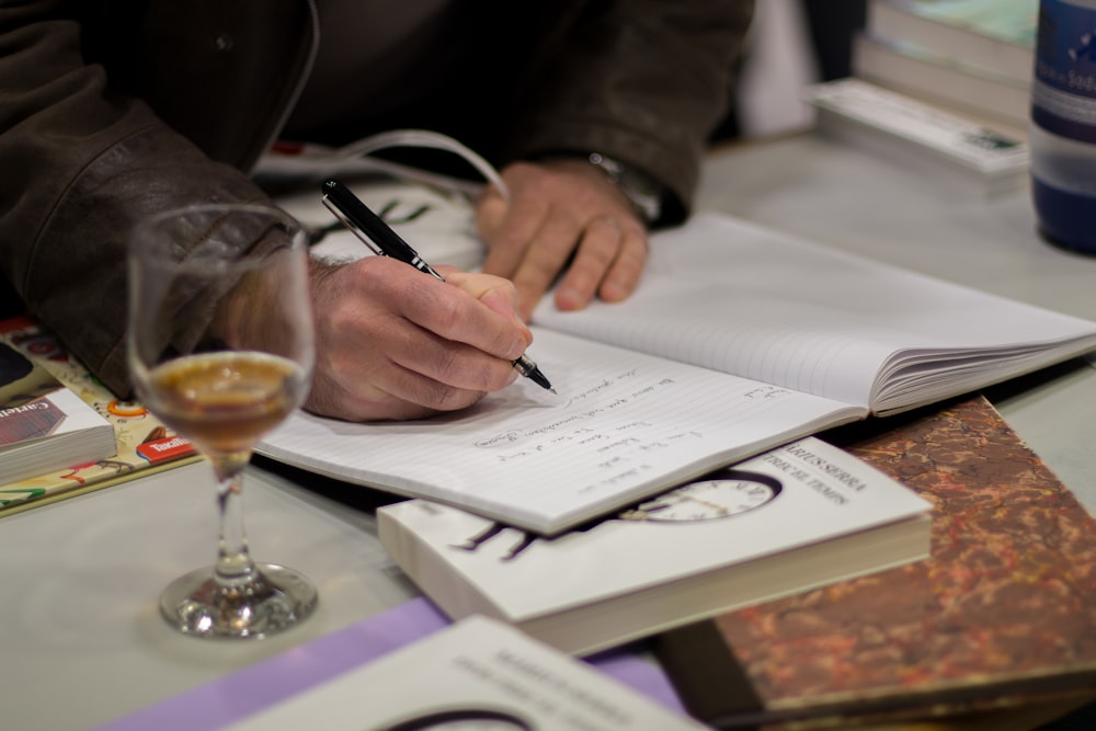 man writing on book