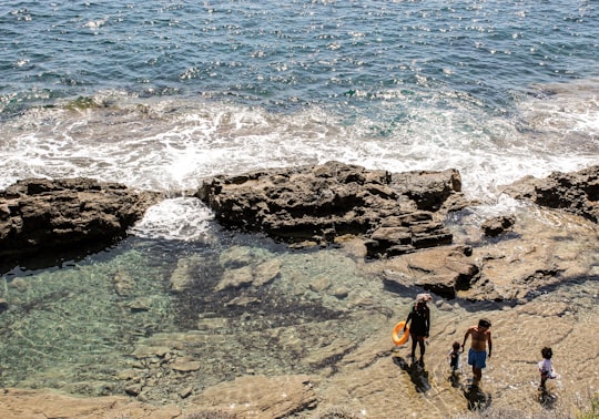 aerial photography of couple with two children walking on shore during daytime in Dénia Spain