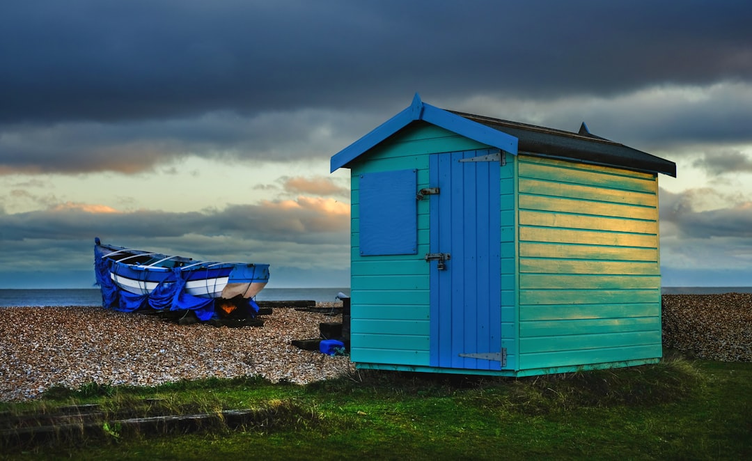  teal and blue wooden shed near boat shed