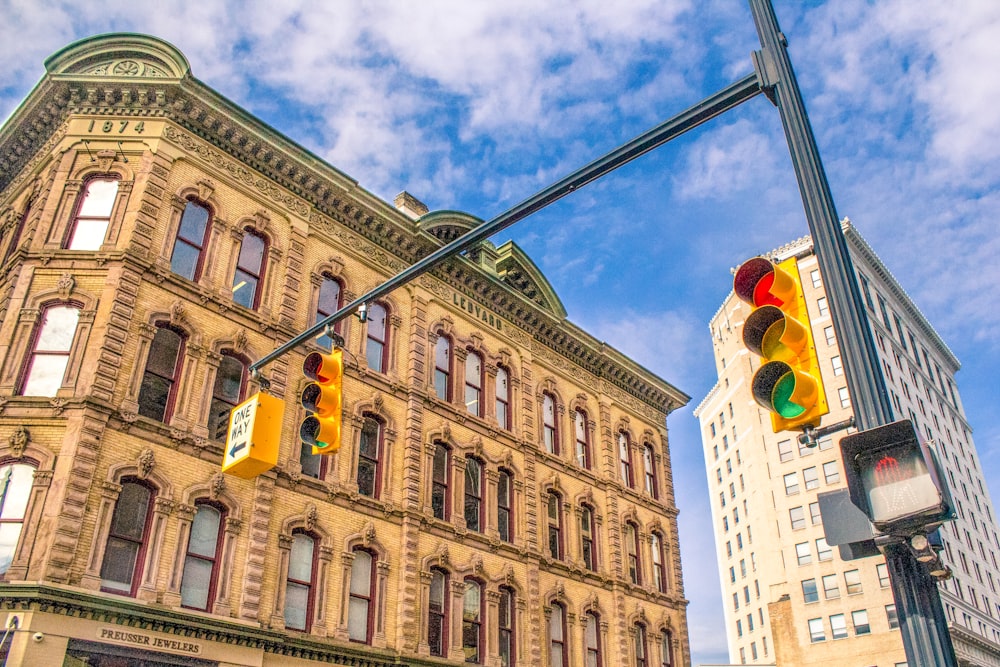 architectural photography of traffic lights near beige painted establishment