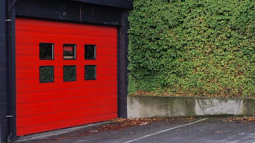 red and black wooden shed beside grass