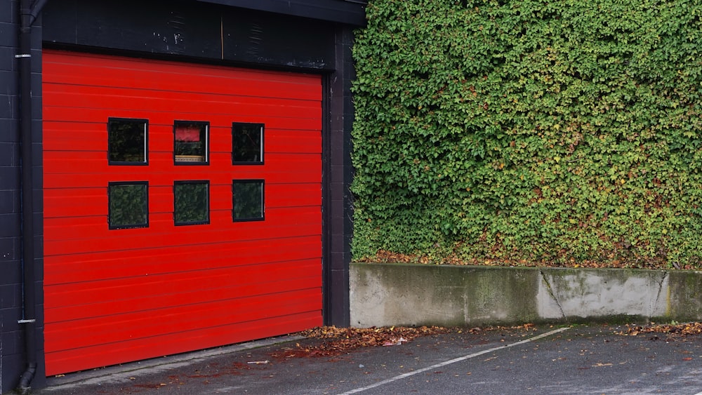 red and black wooden shed beside grass