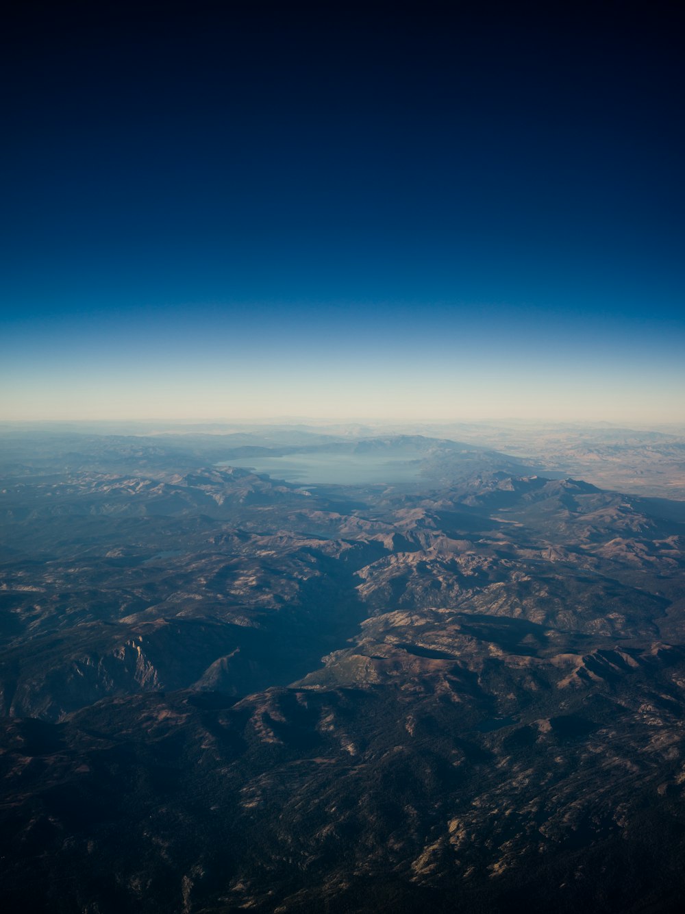 satellite photography of rocky mountains near lake