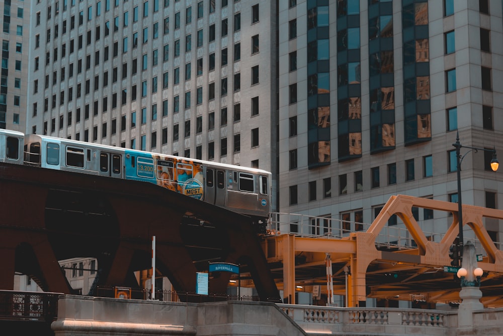 gray train in railway near high-rise building