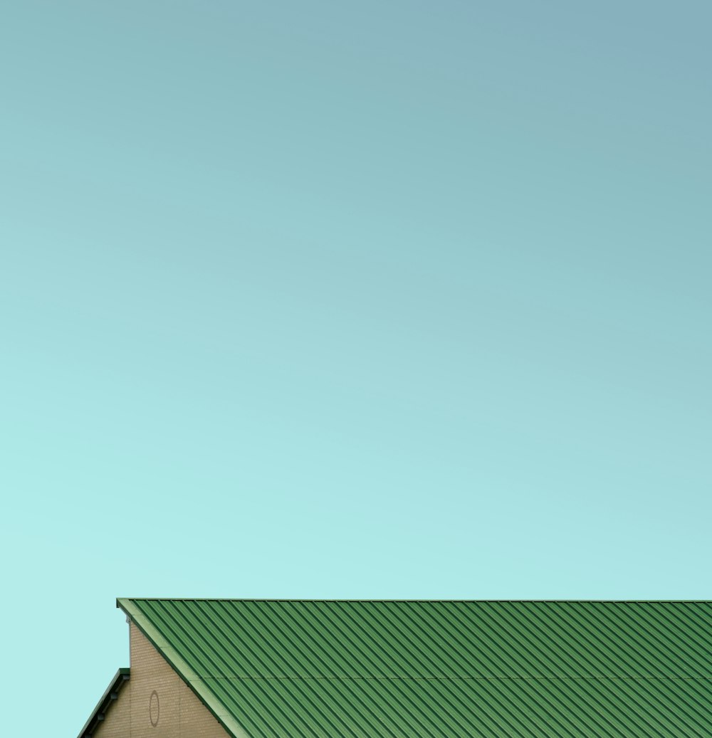 Techo de casa verde bajo cielo azul