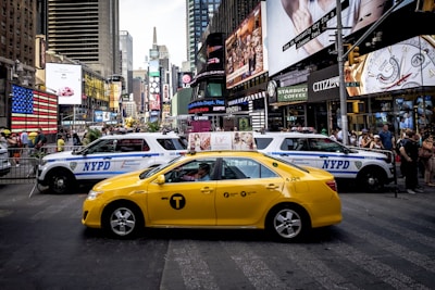 yellow sedan beside police cars