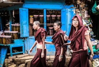 three men walking near grain store during daytime