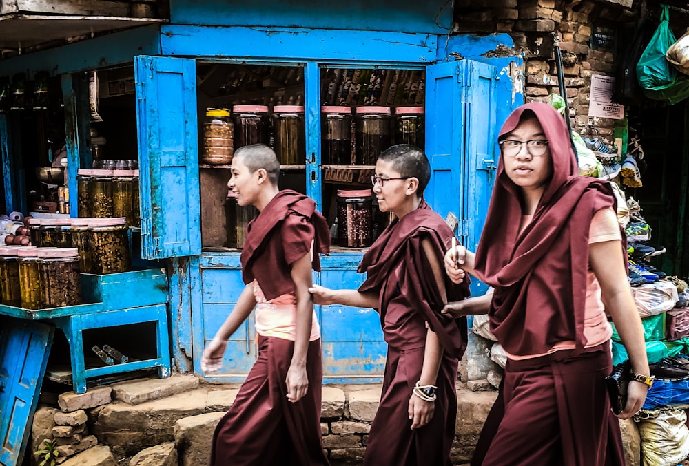 three men walking near grain store during daytime